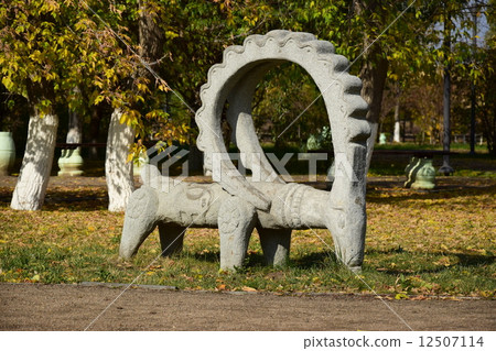 Stone statue featuring a wether with big horns- in the park of Astana, Kazakhstan 12507114