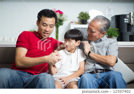 Young Asian child / boy interacting with his father and grand father 12507402