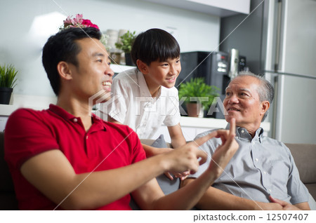 Young Asian child / boy interacting with his father and grand father 12507407