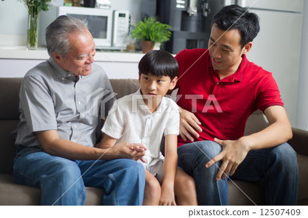Young Asian child / boy interacting with his father and grand father 12507409