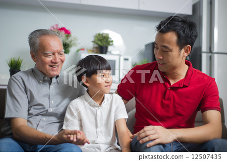 Young asian boy is spending time having conversation with his father and grandfather 12507435