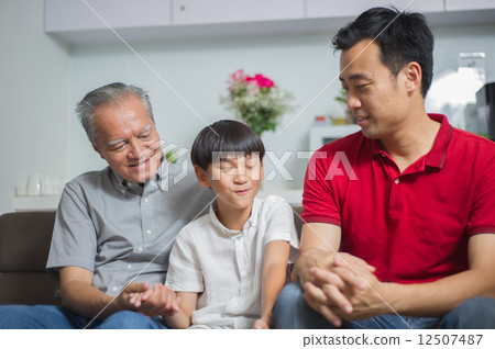 Young asian boy is playing guess game with his father and grandfather or making christmas wishes  12507487