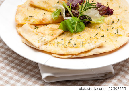 garlic pita bread pizza with salad on top 12508355