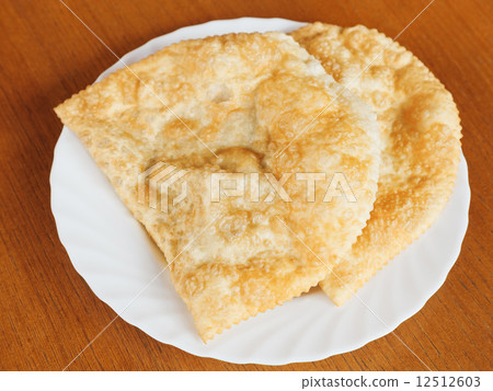 top view of cheburek pie on white plate 12512603