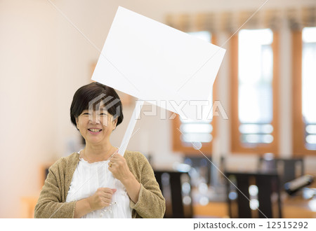 A senior woman with a smile with a placard 12515292