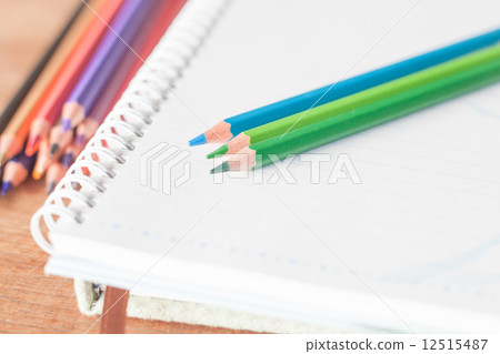 Closeup colorful pencils on spiral notebook and green notebook Closeup colorful pencils on spiral notebook and green notebook 12515487
