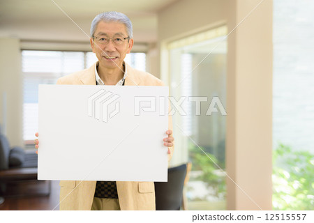 站立的老人拿著一whiteboard在客廳 12515557