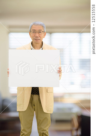 站立的老人拿著一whiteboard在客廳 12515558