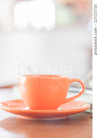 Mini orange coffee cup in coffee shop Mini orange coffee cup in coffee shop 12515710