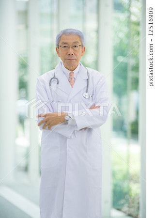 站立拉丁文的灰色醫生，當舒展他的胳膊在一家大醫院的入口附近時 12516909