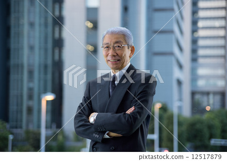 High-rise building in the evening Executive who stands with arms around the city 12517879