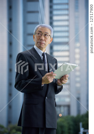 Executive to see the tablet in a skyscraper at dusk 12517900