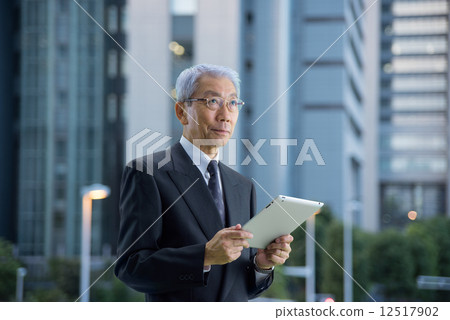 Executive to see the tablet in a skyscraper at dusk 12517902
