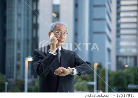 行政人員在黃昏時在摩天大樓打電話 12517915