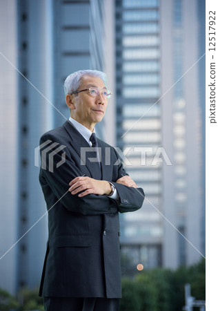 High-rise building in the evening Executive who stands with arms around the city High-rise building in the evening Executive who stands with arms around the city 12517922