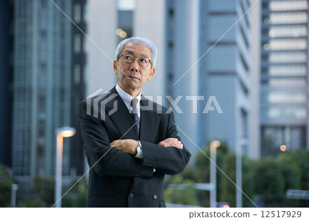 High-rise building in the evening Executive who stands with arms around the city 12517929