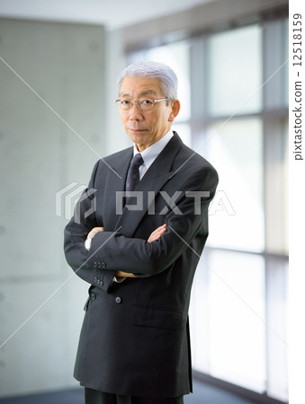 A businessman standing by the window A businessman standing by the window 12518159