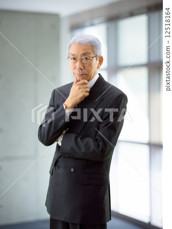 A businessman standing by the window A businessman standing by the window 12518164