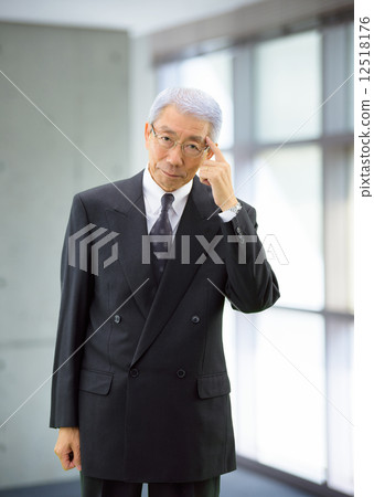 A businessman standing by the window 12518176