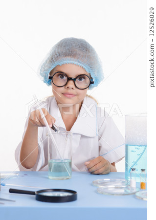 Chemist pours reagent liquid in the flask Chemist pours reagent liquid in the flask 12526029