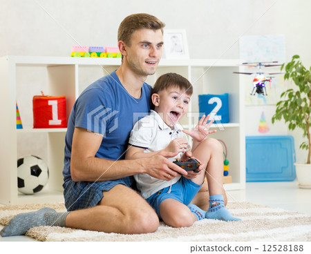 Father and son playing with RC helicopter toy 12528188