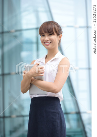 Young successful Chinese business woman using mobile device tablet iPad in front of office building Young successful Chinese business woman using mobile device tablet iPad in front of office building 12528272