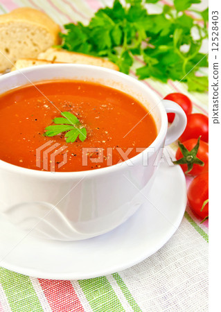 Soup tomato in bowl with tomatoes on linen napkin Soup tomato in bowl with tomatoes on linen napkin 12528403