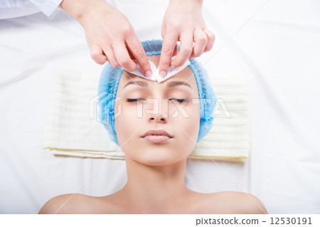 Skin care - woman cleaning face by beautician 12530191