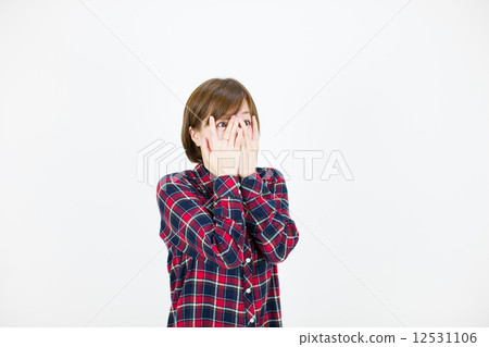 A young lady who covers his face with surprise and his eyes wide open A young lady who covers his face with surprise and his eyes wide open 12531106