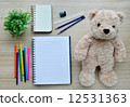 Blank paper, color paint and bear doll on the wood table - Top view 12531363