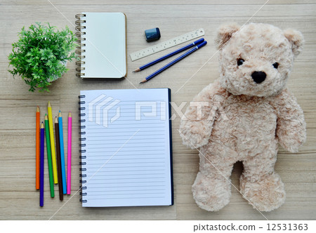 Blank paper, color paint and bear doll on the wood table - Top view Blank paper, color paint and bear doll on the wood table - Top view 12531363