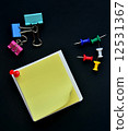 Note pad, Pushpin and Binder clip on black background 12531367