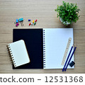 Blank notebook and Pushpin on the wood table - Top view 12531368