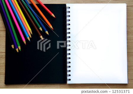 Blank paper and colorful pencils on the wood table - Top view Blank paper and colorful pencils on the wood table - Top view 12531371