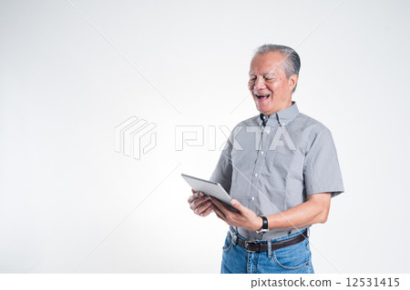 Old man holding tablet looking happy Old man holding tablet looking happy 12531415