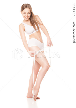 Slimming woman measuring thigh with tape Slimming woman measuring thigh with tape 12534336