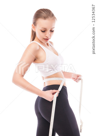 Slimming woman measuring thigh with tape 12534367