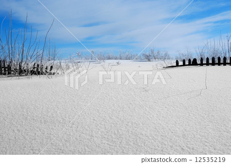 Wooden fence covered with snow 12535219