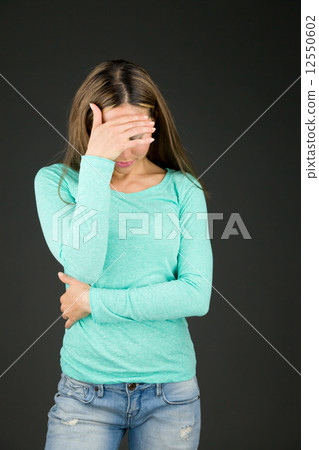 model isolated on plain background ashamed hiding face in hand model isolated on plain background ashamed hiding face in hand 12550602
