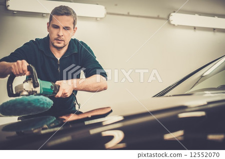Man on a car wash polishing car with a polish machine 12552070