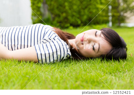 採取在草坪的婦女休息 採取在草坪的婦女休息 12552421