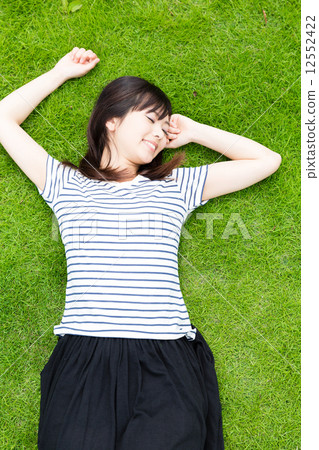 A woman taking a nap on the lawn A woman taking a nap on the lawn 12552422