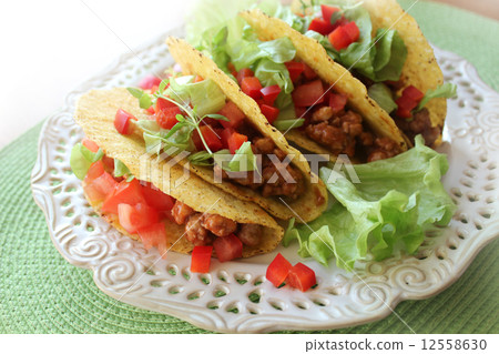 Mexican food - tacos with meat, lettuce and tomatoes  12558630