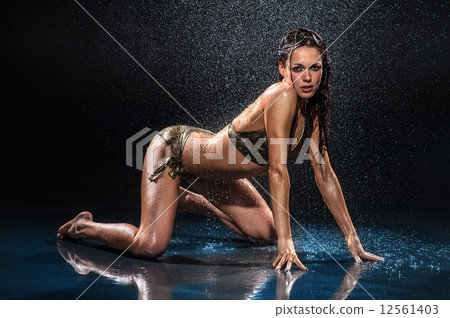 Sexy woman standing on her knees under rain. Studio photo 12561403