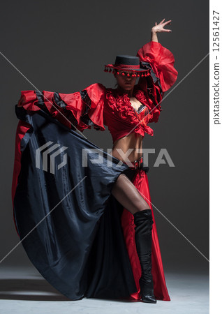 Woman in beautifull red dress dancing in a studio 12561427