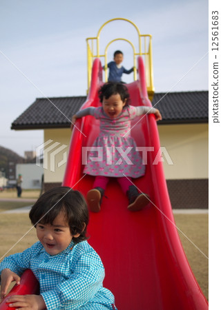 Boys and girls playing on the slide 12561683