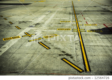 black and yellow airport markings on concrete 12564726