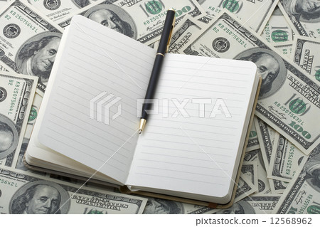 notebook with black pen on 100 dollar banknotes 12568962