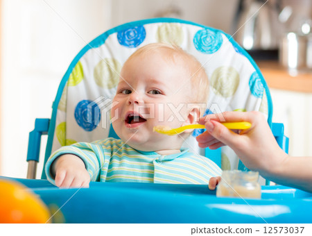 baby eating food on kitchen 12573037