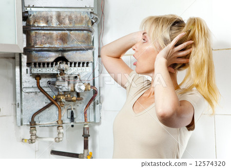 The young woman is upset by that the gas water heater has broken.. 12574320